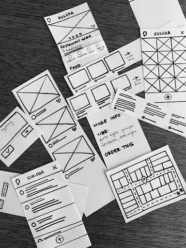 Paper prototype cards laid out on table