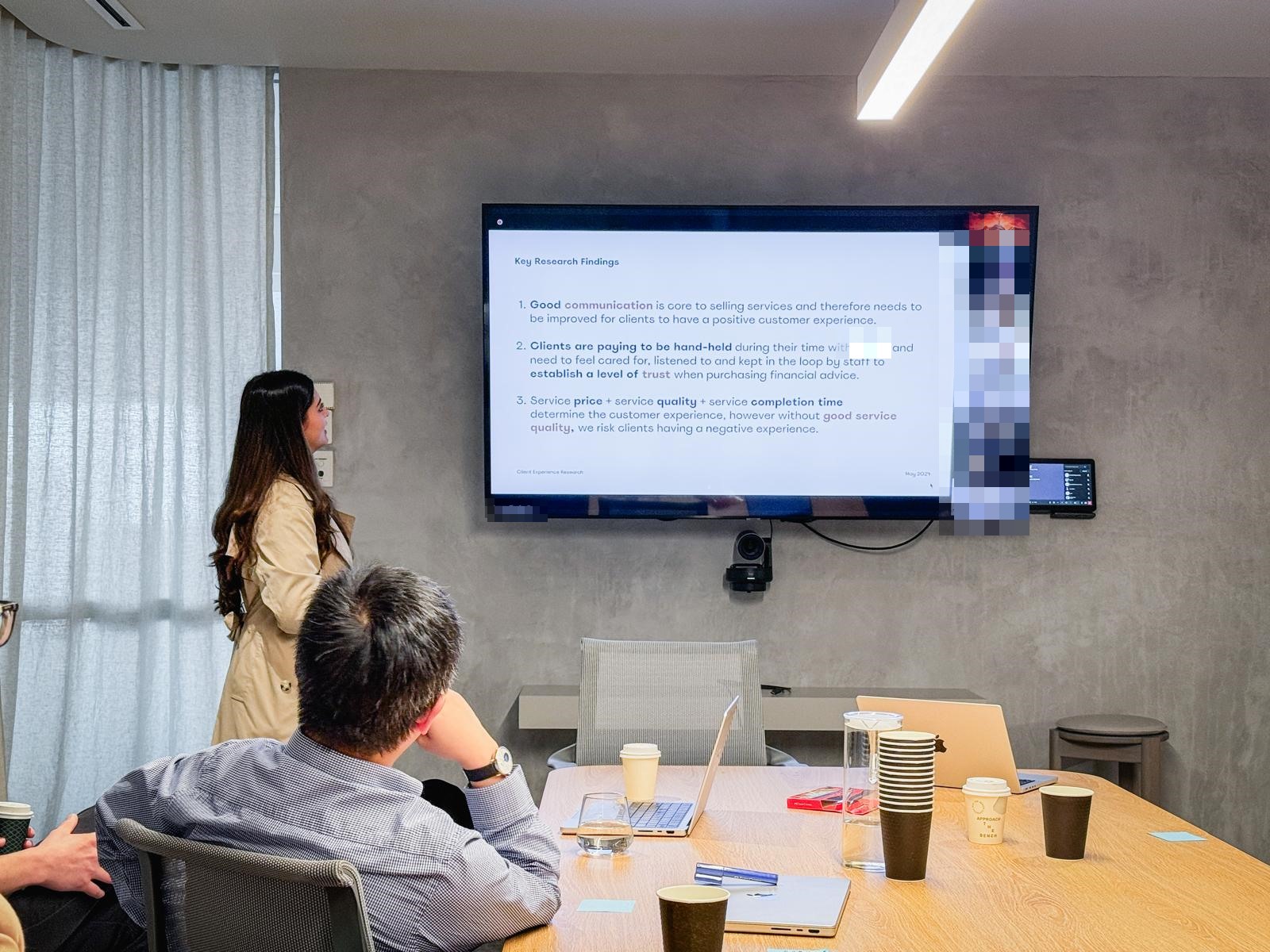 Noma presenting the key client-experience research findings to colleagues in the room and on a video call