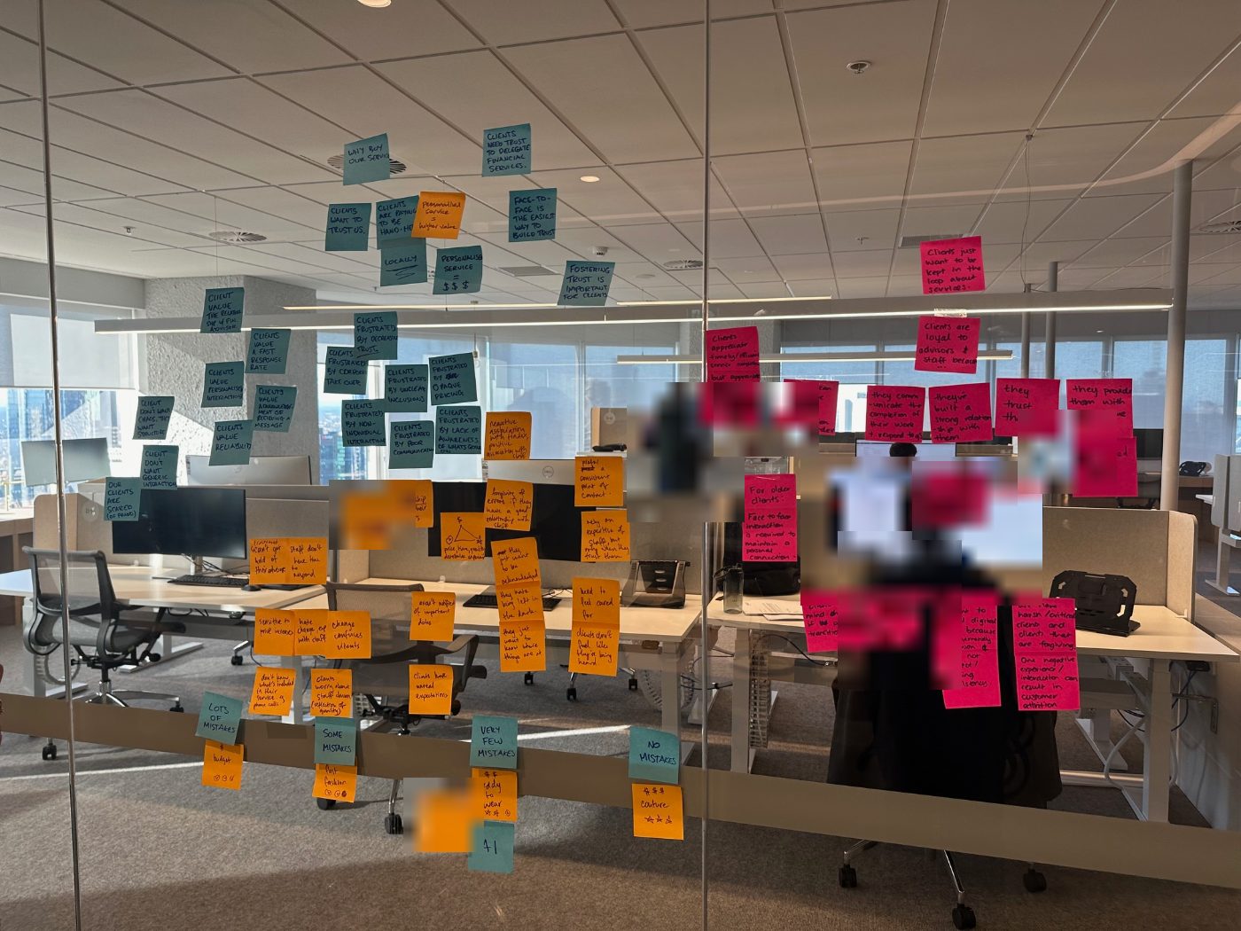 Affinity map of client and staff insights on a glass wall during the discovery workshop